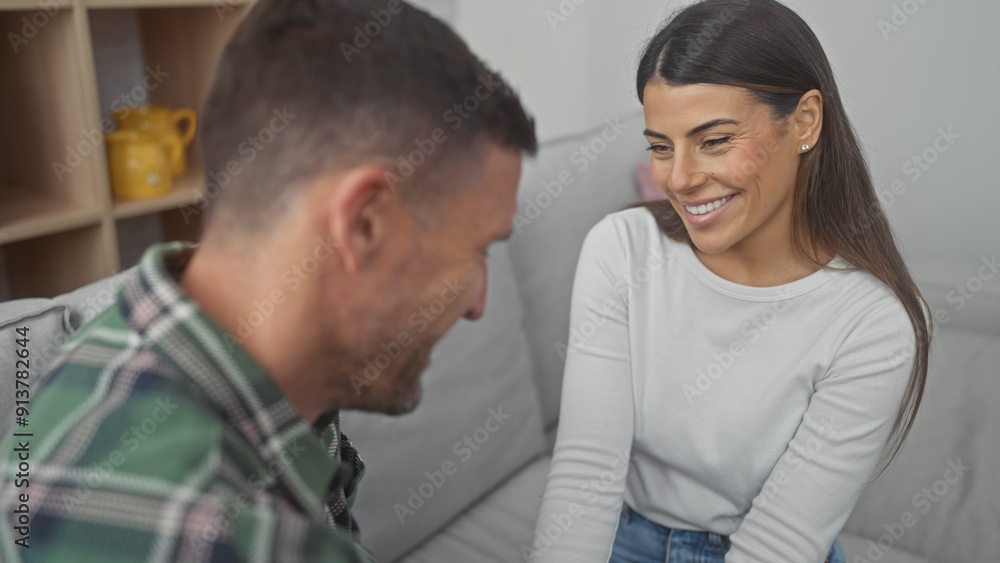 Smiling hispanic woman enjoying a cozy moment with a man on a sofa at home, evoking themes of love and togetherness. Smiling hispanic woman enjoying a cozy moment with a man on a sofa at home, evoking themes of love and togetherness.