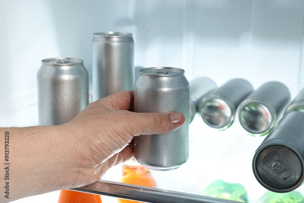 Woman taking can of beer from refrigerator, closeup Woman taking can of beer from refrigerator, closeup