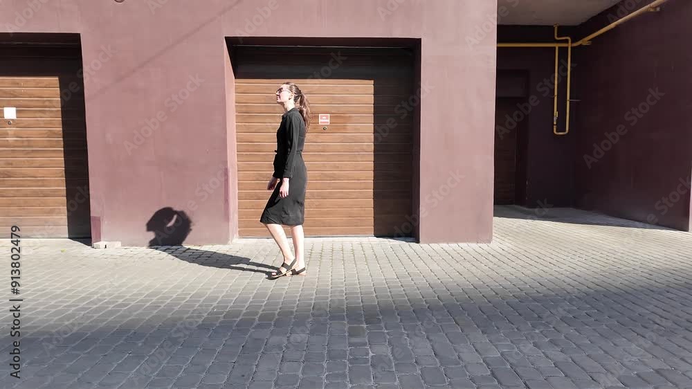 Woman walking in the city wearing elegant black dress Woman walking in the city wearing elegant black dress