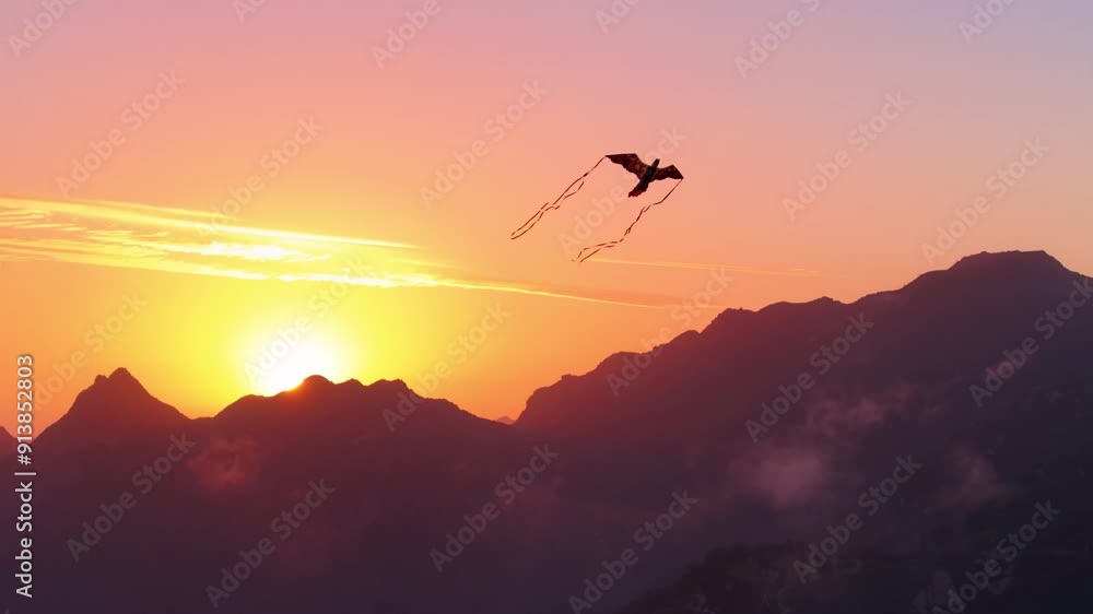 As the sun sets peacefully, a colorful kite gracefully soars in the sky against the backdrop of majestic mountains, creating a tranquil and picturesque atmosphere with serene silhouettes As the sun sets peacefully, a colorful kite gracefully soars in the sky against the backdrop of majestic mountains, creating a tranquil and picturesque atmosphere with serene silhouettes