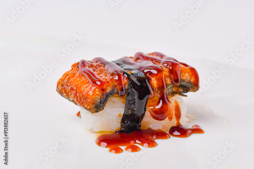 Eel sushi topped with sweet sauce, ready to eat.