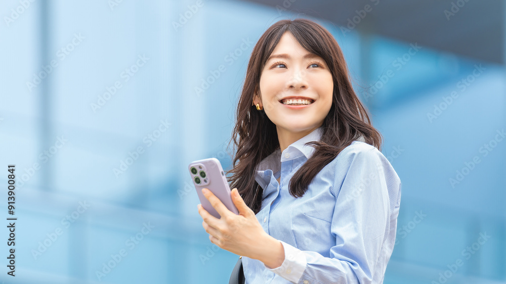 スマートフォンを持つ笑顔の日本人ビジネスウーマン スマートフォンを持つ笑顔の日本人ビジネスウーマン