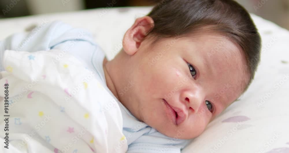 A small newborn baby is cooing and stretching as it looks at things and people that are around in the room. A small newborn baby is cooing and stretching as it looks at things and people that are around in the room.