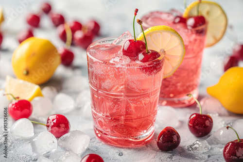 Two glasses with refreshing ice cold cherry lemonade decorated with mint and lemon