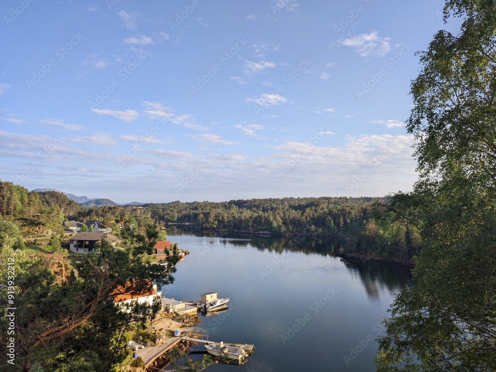 Obraz premium Enjoy a picturesque view of a serene lake landscape with clear blue skies and lush greenery