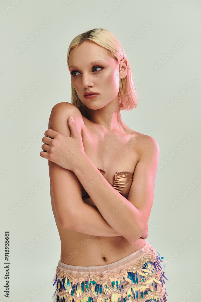 A young woman poses elegantly in holographic attire with a thoughtful expression. A young woman poses elegantly in holographic attire with a thoughtful expression.