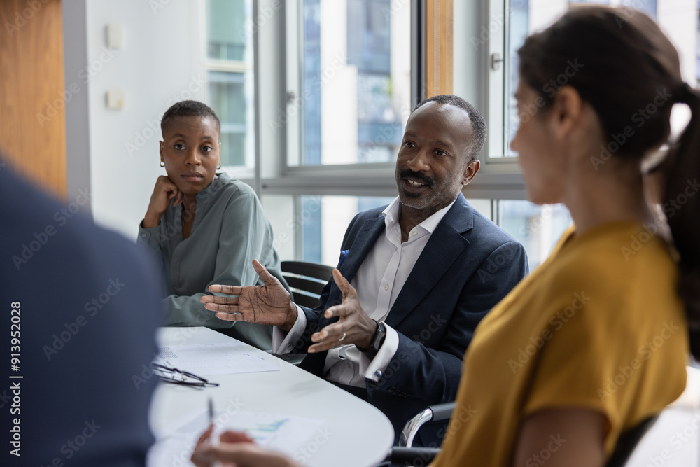 Mature black businessman leading a corporate business office meeting Mature black businessman leading a corporate business office meeting