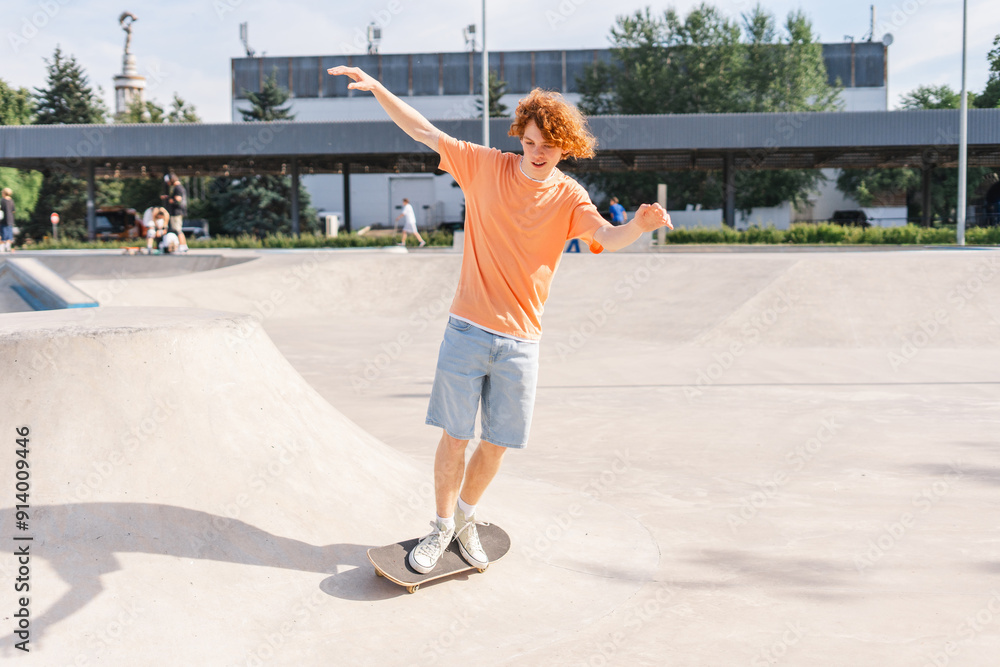 Curly ginger teenage boy riding on skateboard on the street making extreme trick Curly ginger teenage boy riding on skateboard on the street making extreme trick