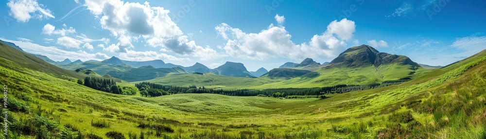 Breathtaking panoramic view of lush green hills and majestic mountains under a bright blue sky with fluffy clouds. Breathtaking panoramic view of lush green hills and majestic mountains under a bright blue sky with fluffy clouds.