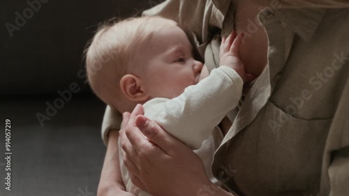 Close up of unrecognizable young nursing woman gently holding baby while breastfeeding, creating bonding and emotional connection between mother and child photo