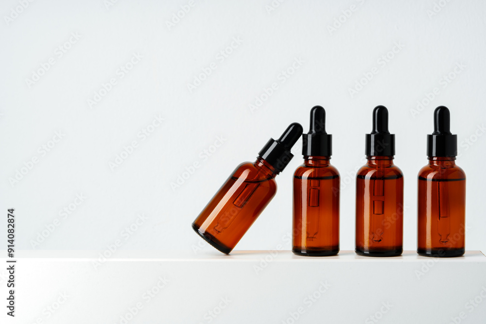 Row of various brown glass dropper bottles isolated on white background Row of various brown glass dropper bottles isolated on white background