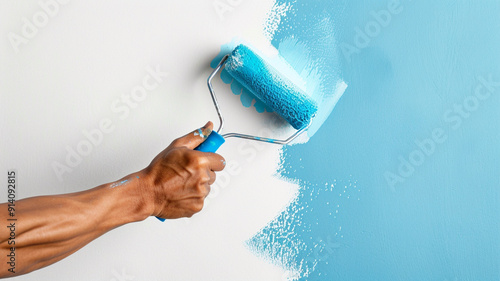 closeup of a hand holding a paint roller with blue paint