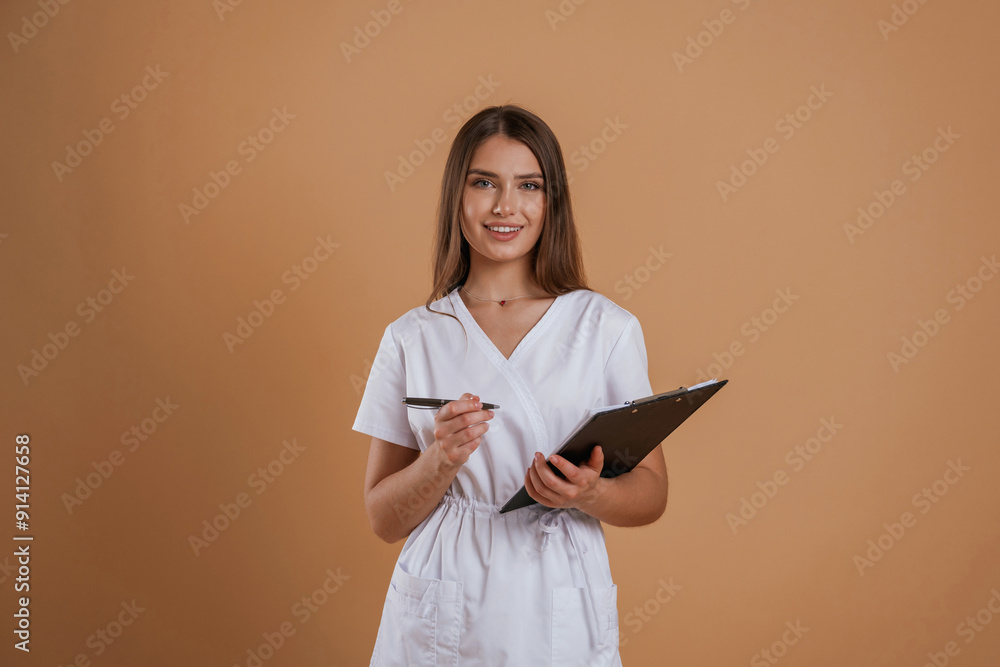 Documents in hands. Young pretty woman is against background in the studio Documents in hands. Young pretty woman is against background in the studio