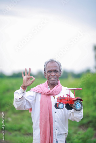 Indian farmer, equipped with a miniature tractor toy photo