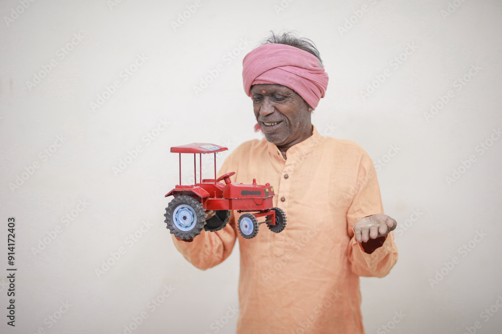 Indian farmer, equipped with a miniature tractor toy Indian farmer, equipped with a miniature tractor toy