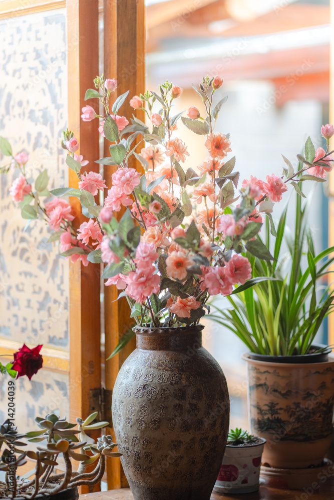 Fototapeta premium Bouquet of dry roses in vintage vase near the window