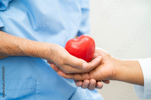 Asian doctor give red heart to elderly woman in her hand, heart Attack.