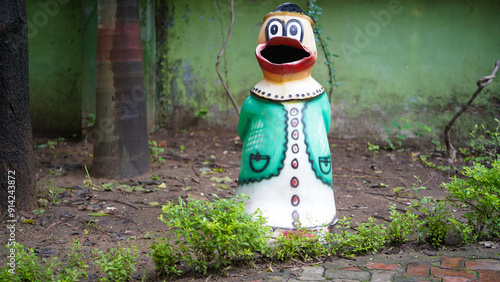 Quirky Trash Can Sculpture in a Park, Colorful Bird-Shaped Trash Bin, Whimsical Waste Bin in a Green Setting, Feathered Friend for the Environment, 
Guardian of the Green, Nature's Watchful Eye photo