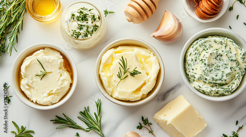 Assorted flavored butters including herb butter, garlic butter, and honey butter on a marble background photo