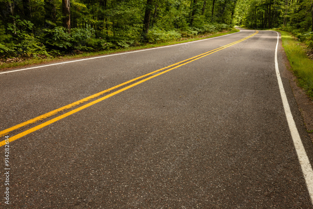 Fototapeta premium Scenic Highway K disappears around the turn in Vilas County, Wisconsin in late August