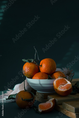 Small ripe oranges with leaves in a cream colored bowl, Fruits Light and Shade Photography
