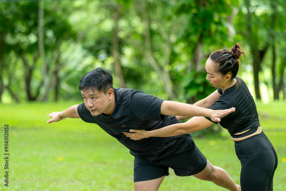 A man and a woman are practicing yoga in a park A man and a woman are practicing yoga in a park