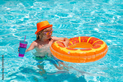 Child swimming in pool play with floating ring. Summer kids cocktail. Smiling cute kid in sunglasses swim with inflatable rings in pool in summer day. photo