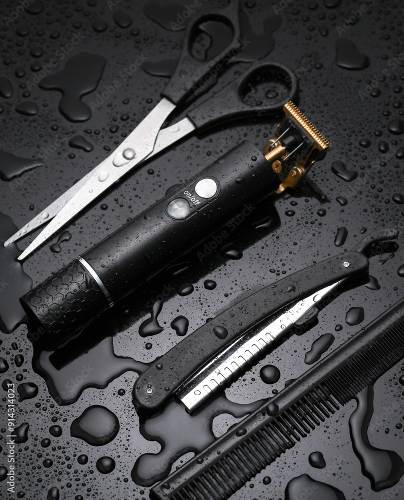 Fototapeta premium Trimmer with scissors, straight razor and comb on a black background with water drops. Barber tools