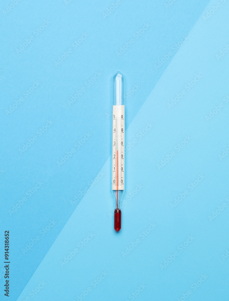 Thermometer on a blue background. Top view Thermometer on a blue background. Top view