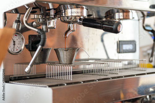 Картината върху платно Fresh coffee dropping from the coffee making machine down into the cup