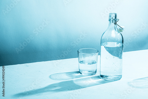 Clear glass water bottle with glass, cyan tinted


