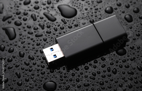 Fényképezés USB flash drive in drops of water on black background