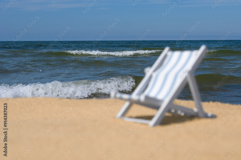 Unfocused empty sun lounger at a sandy beach. Back focus Unfocused empty sun lounger at a sandy beach. Back focus