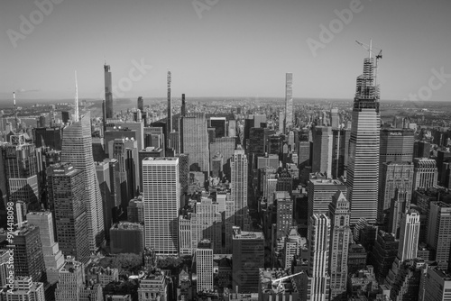 Aerial panoramic black and white view of Manhattan, showcasing countless skyscrapers and the distant horizon. A powerful and urban, yet sober image