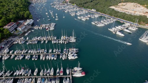 A stunning view captured by drone along the shores of the Mediterranean Sea. The beautiful Croatian coast during a summer vacation, with boats and yachts slicing through the sea waters.