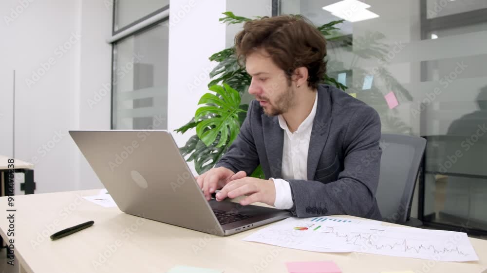 Focused trader working on a laptop in a modern office, analyzing market trends and planning investment strategies. Perfect for illustrating financial growth and professional trading. Focused trader working on a laptop in a modern office, analyzing market trends and planning investment strategies. Perfect for illustrating financial growth and professional trading.