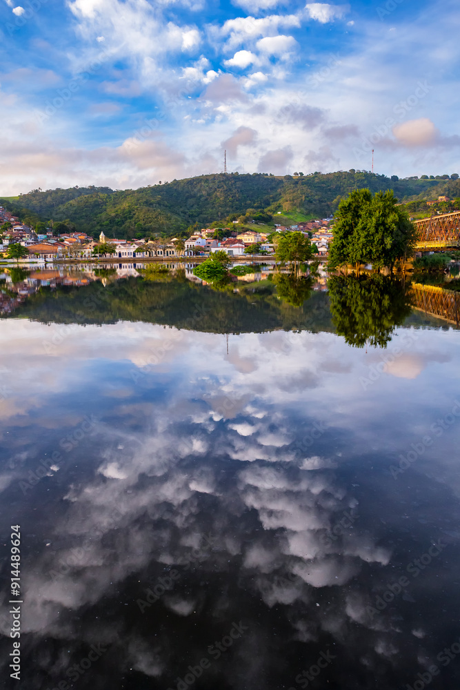 Fototapeta premium Bridge that crosses the city of Cachoeira in Bahia, and the beautiful sky and boats on the river