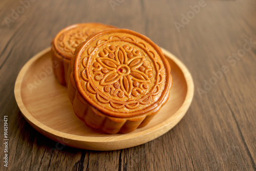 Mooncake on a wooden plate, tradition chinese mooncake on wood table. Mid Autumn celebration, Happy Chinese translation Mid Autumn festival.