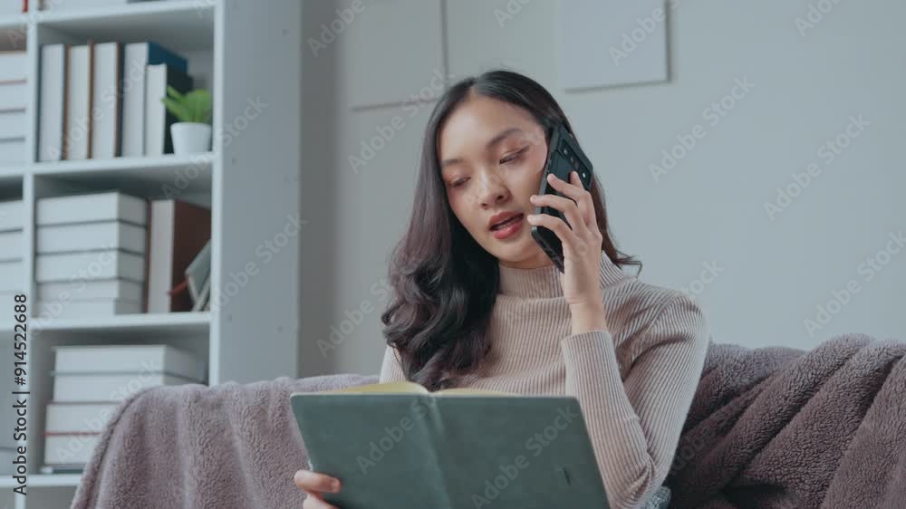 Young businesswoman multitasking in a modern office, talking on the phone while reviewing important documents. Efficient and focused in a contemporary workspace Young businesswoman multitasking in a modern office, talking on the phone while reviewing important documents. Efficient and focused in a contemporary workspace