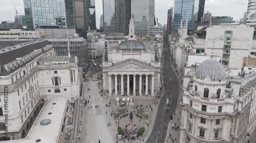 Drone aerial shot flying back away from the Bank of England in Central London, with the high rise skyscrapers in the background on a normal cloudy day photo