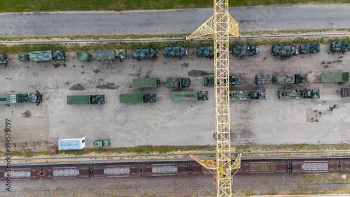 Drone photography of military convoy at train station during summer day photo