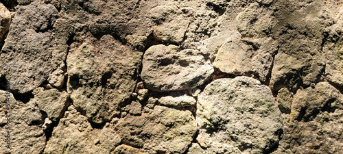 old stone wall with shadows and sunlight, rustic background