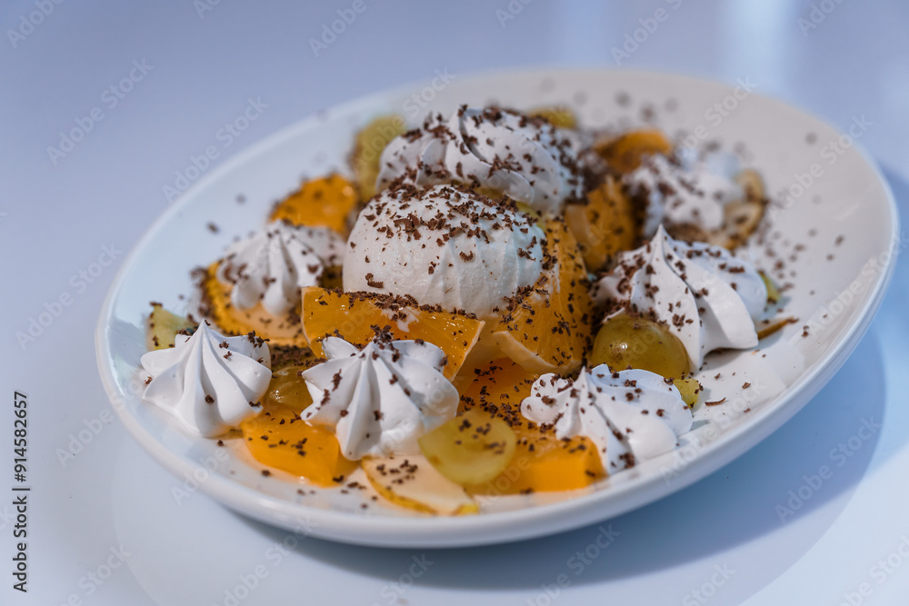 Ice cream with fruits and chocolate on a white plate Ice cream with fruits and chocolate on a white plate