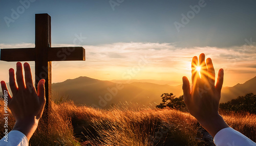 Hands raised in worship in front of a cross at sunset