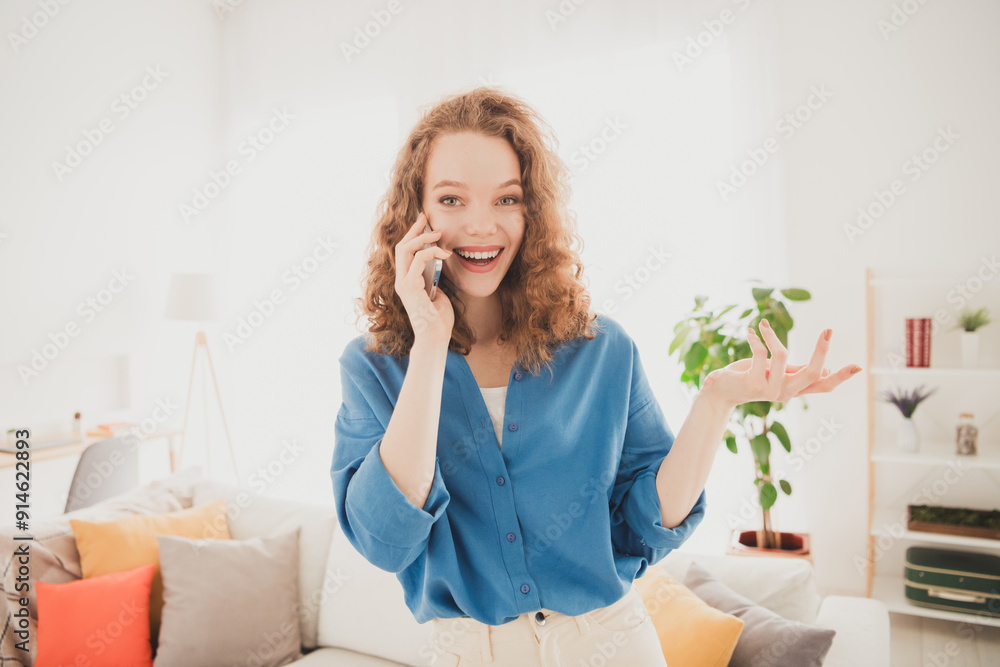 Photo of attractive trendy young woman talk phone excited blue shirt move new apartment home interior indoors Photo of attractive trendy young woman talk phone excited blue shirt move new apartment home interior indoors