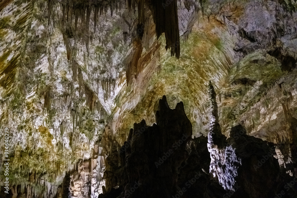 Explore remarkable stalagmite formations glowing in a vast underground cave. Explore remarkable stalagmite formations glowing in a vast underground cave.