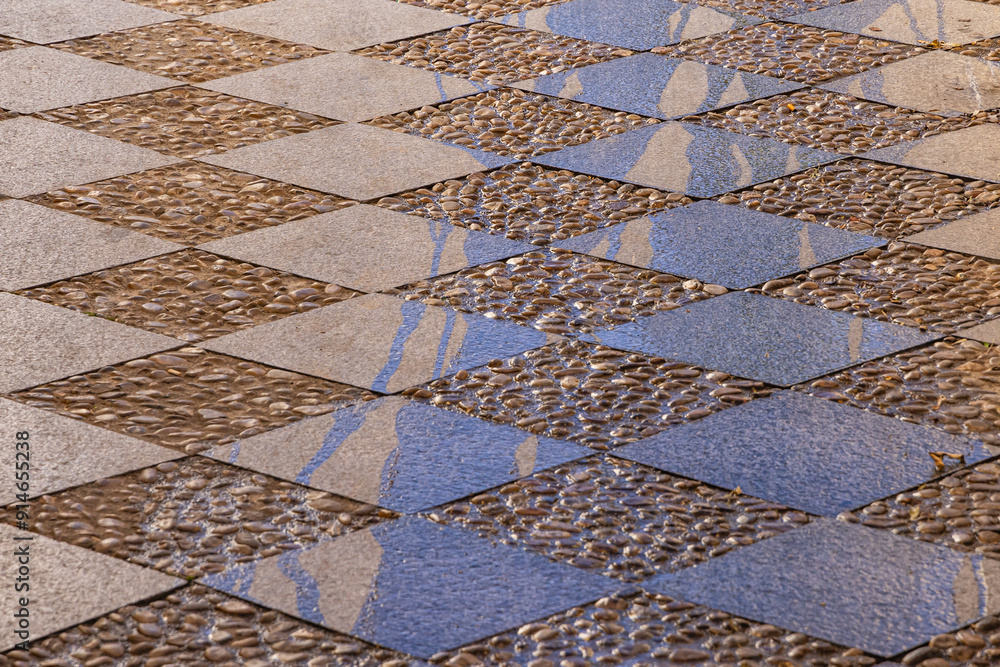 Cut stone tiles and cobbles pave a plaza in Granada.