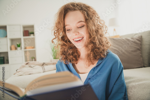 Photo of happy young girl read interesting book blue shirt enjoy live new apartment room light house flat indoor