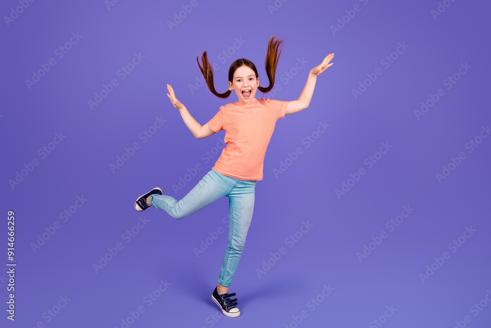 Full length photo of lovely small girl dancing good mood have fun dressed stylish red garment isolated on violet color background Full length photo of lovely small girl dancing good mood have fun dressed stylish red garment isolated on violet color background