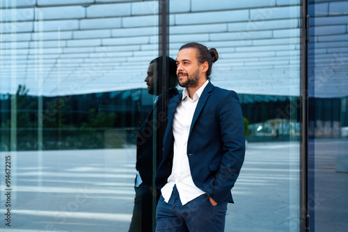 Successful businessman in suit with beard standing near office building confidently looking away. Hispanic male business person side view portrait. Free space. Modern Business people